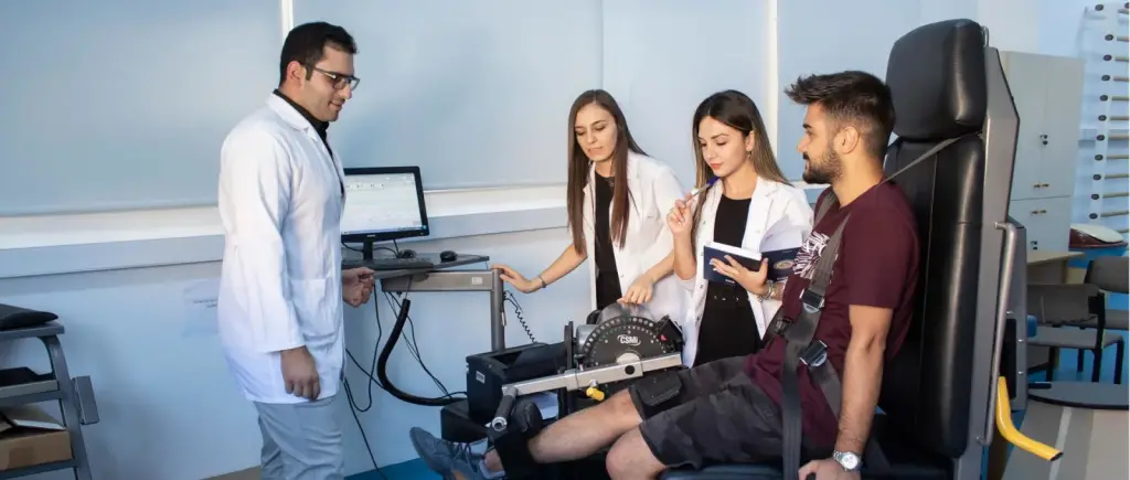 طلاب العلاج الطبيعي والتأهيل في جامعة شرق البحر المتوسط أثناء قياس قوة الركبة بجهاز إيزوكينتيكي في مختبر القسم