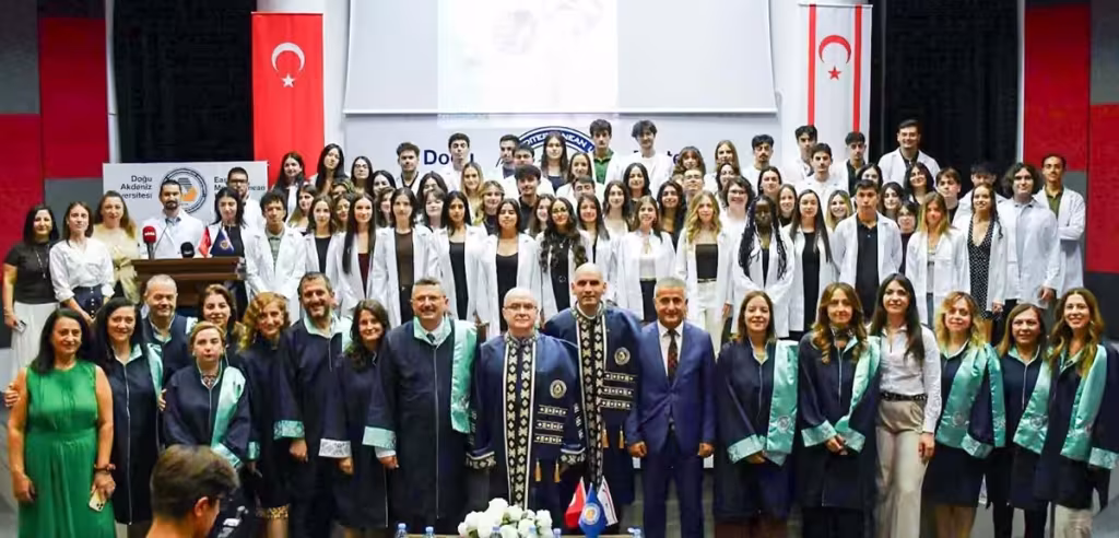 طلبة السنة الأولى في كلية الصيدلة بجامعة شرق البحر المتوسط بالمعطف الأبيض مع أعضاء الهيئة التدريسية